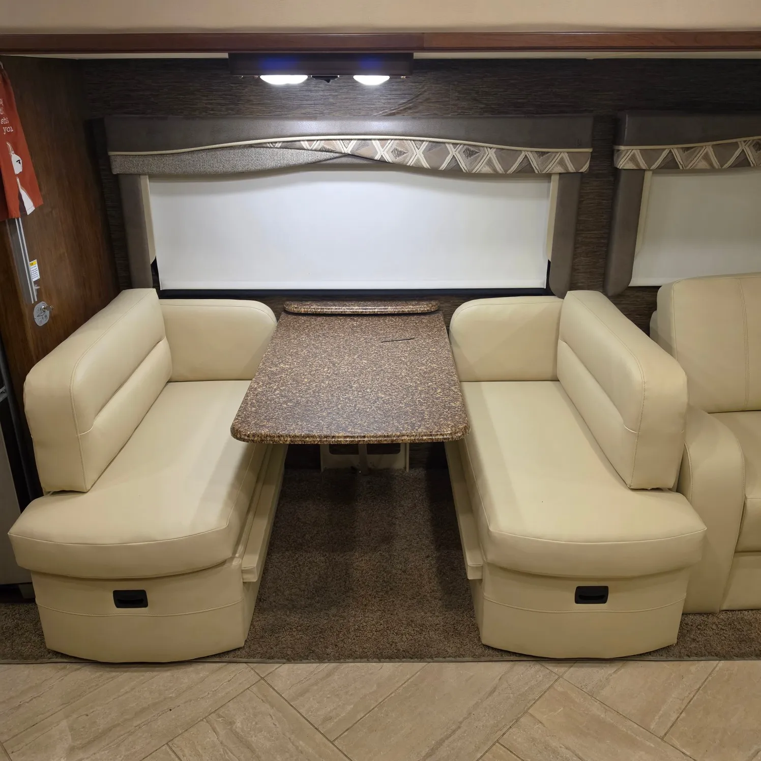 2019 31B, with a sofa set, a table, a carpet on the floor, lights on the wall, and a door