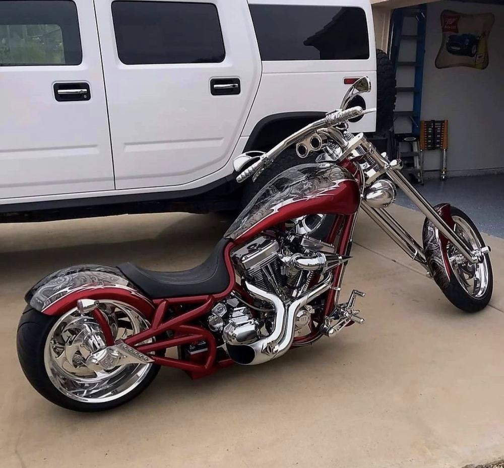 Red and black motorcycle parked in front of a white van